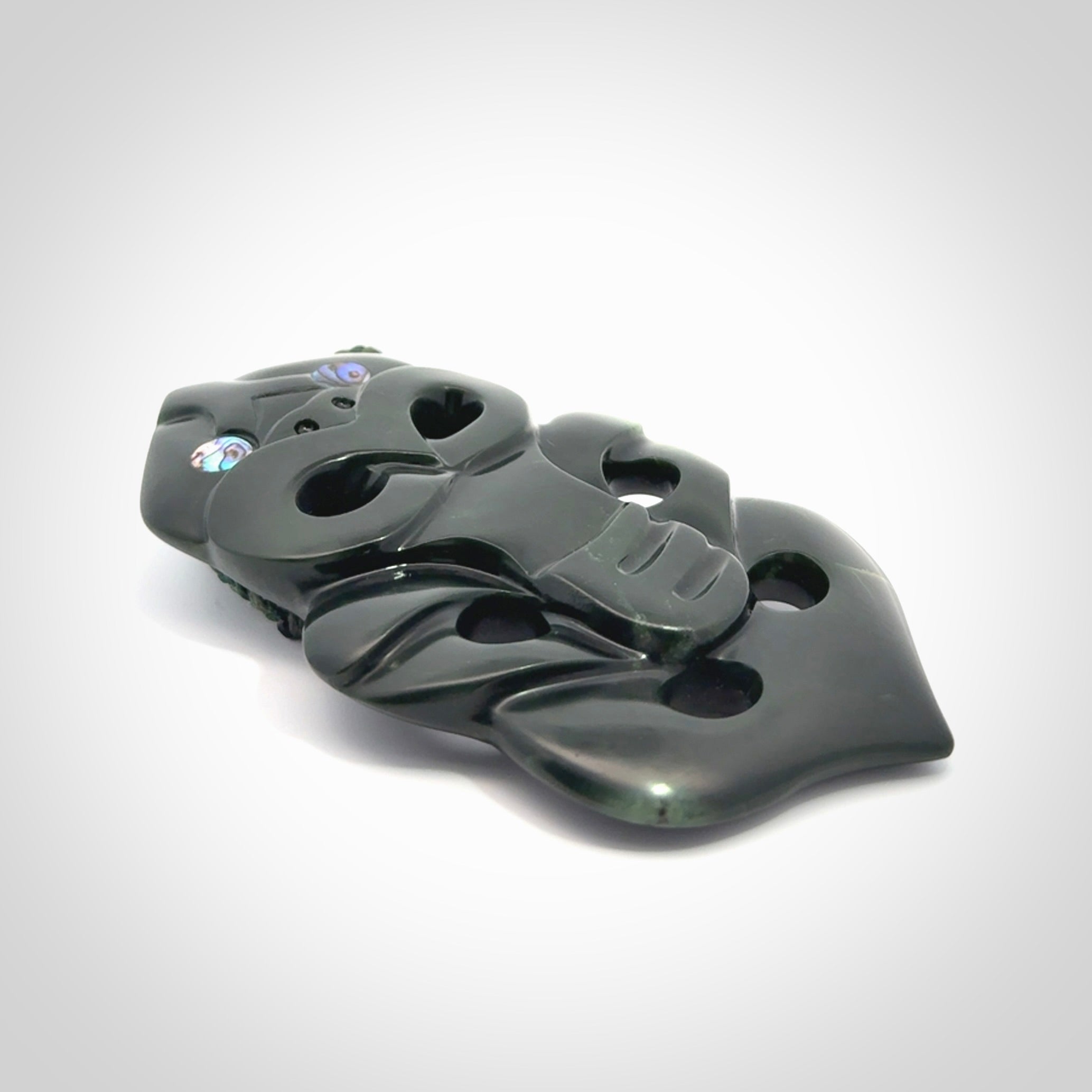 This is a large hand carved New Zealand Jade tiki pendant. It is made from New Zealand Jade and Paua shell.