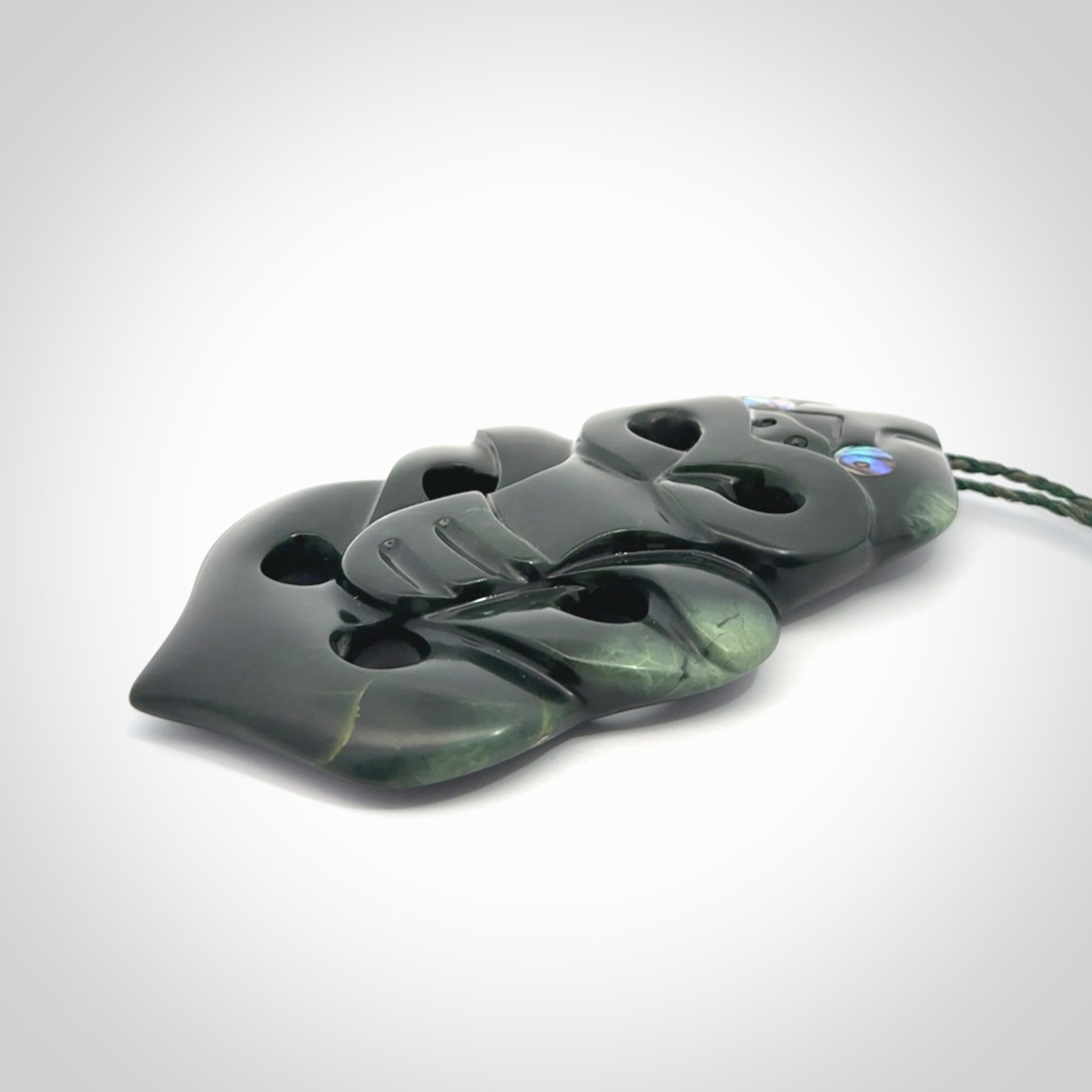 This is a large hand carved New Zealand Jade tiki pendant. It is made from New Zealand Jade and Paua shell.