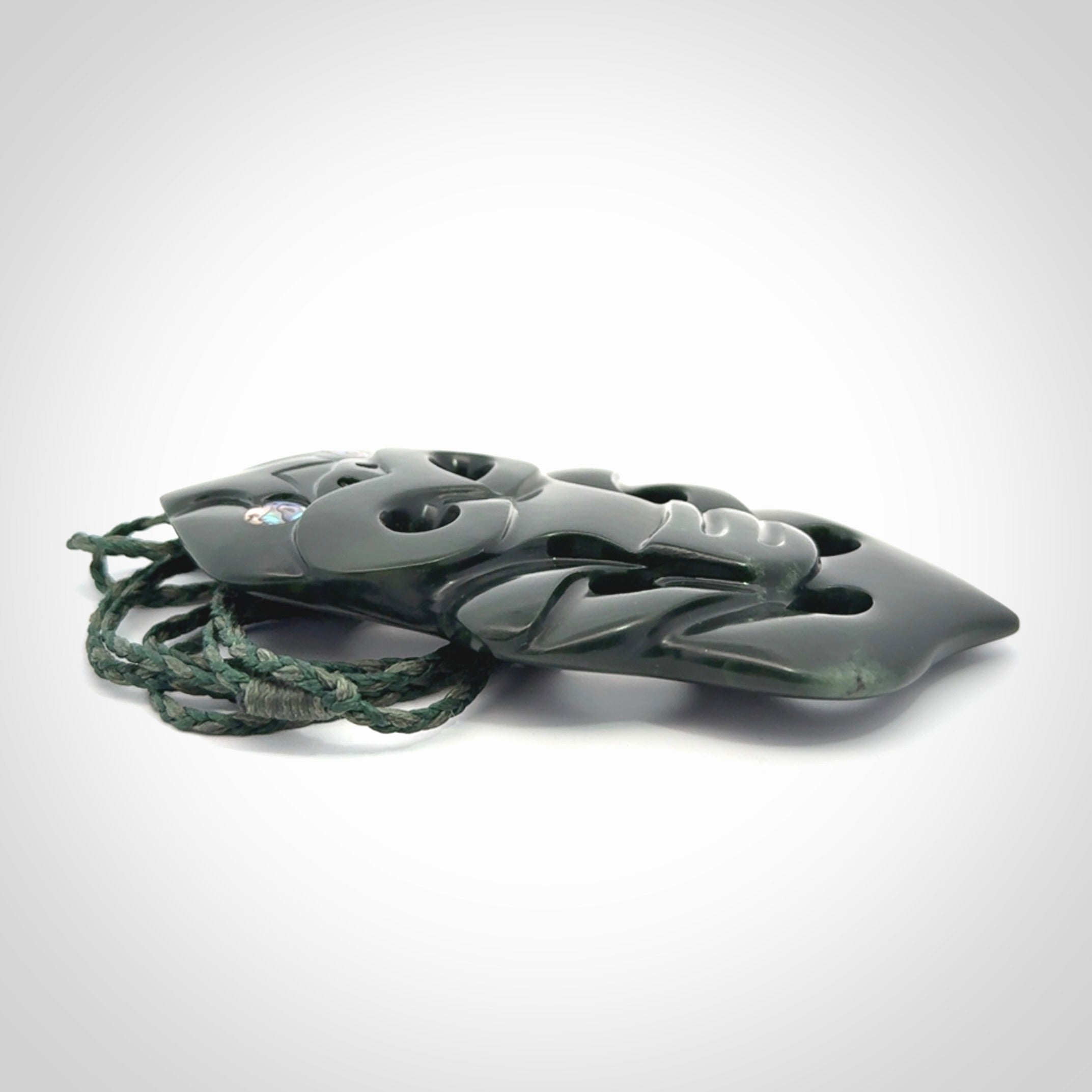 This is a large hand carved New Zealand Jade tiki pendant. It is made from New Zealand Jade and Paua shell.