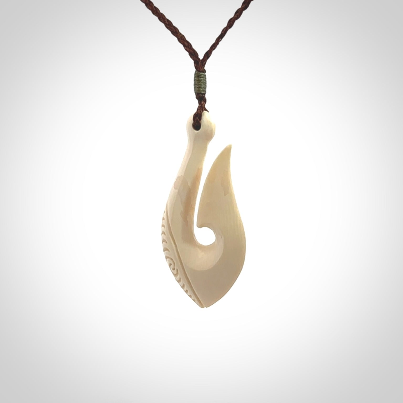 A fish hook necklace (hei-matau) hand-carved in a traditional style from Woolly Mammoth Tusk. Delivered on an adjustable cord in one of our kete pouches.