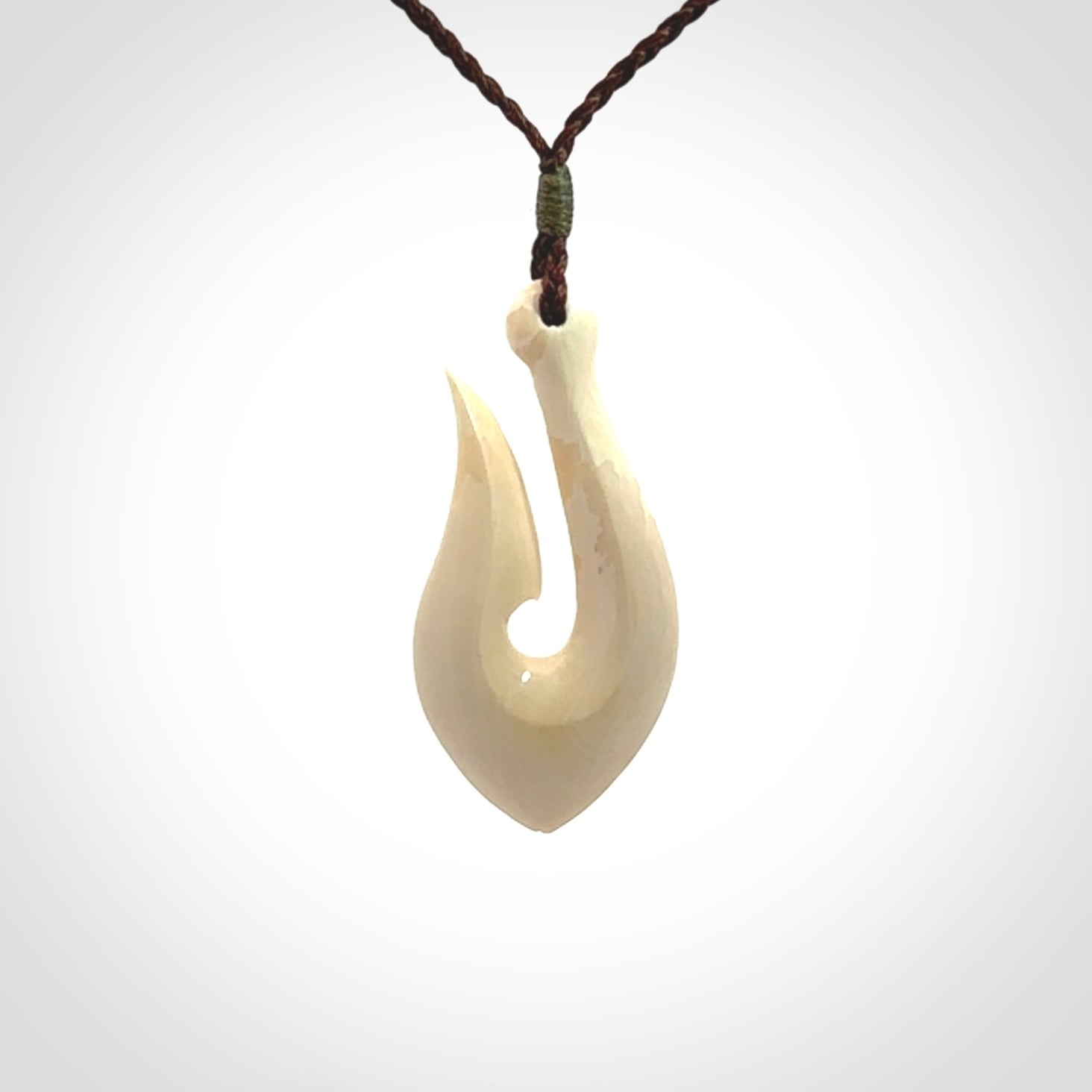 A fish hook necklace (hei-matau) hand-carved in a traditional style from Woolly Mammoth Tusk. Delivered on an adjustable cord in one of our kete pouches.