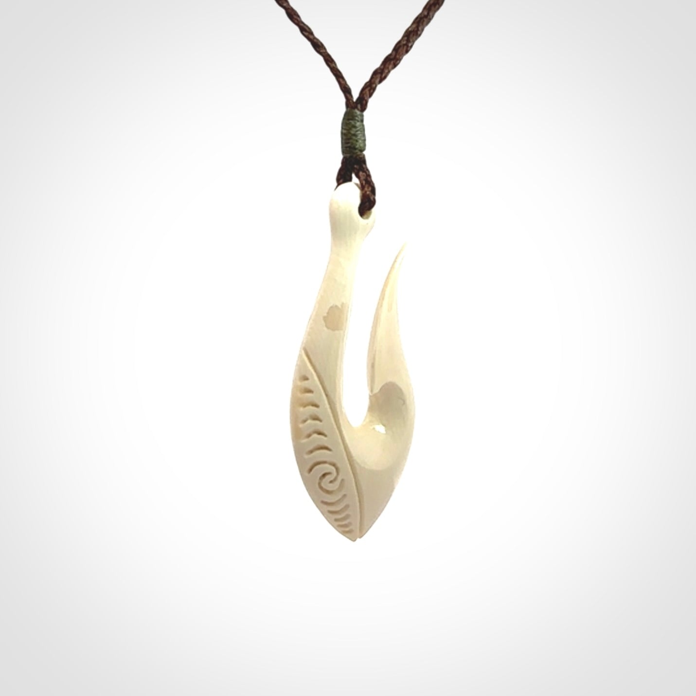 A fish hook necklace (hei-matau) hand-carved in a traditional style from Woolly Mammoth Tusk. Delivered on an adjustable cord in one of our kete pouches.