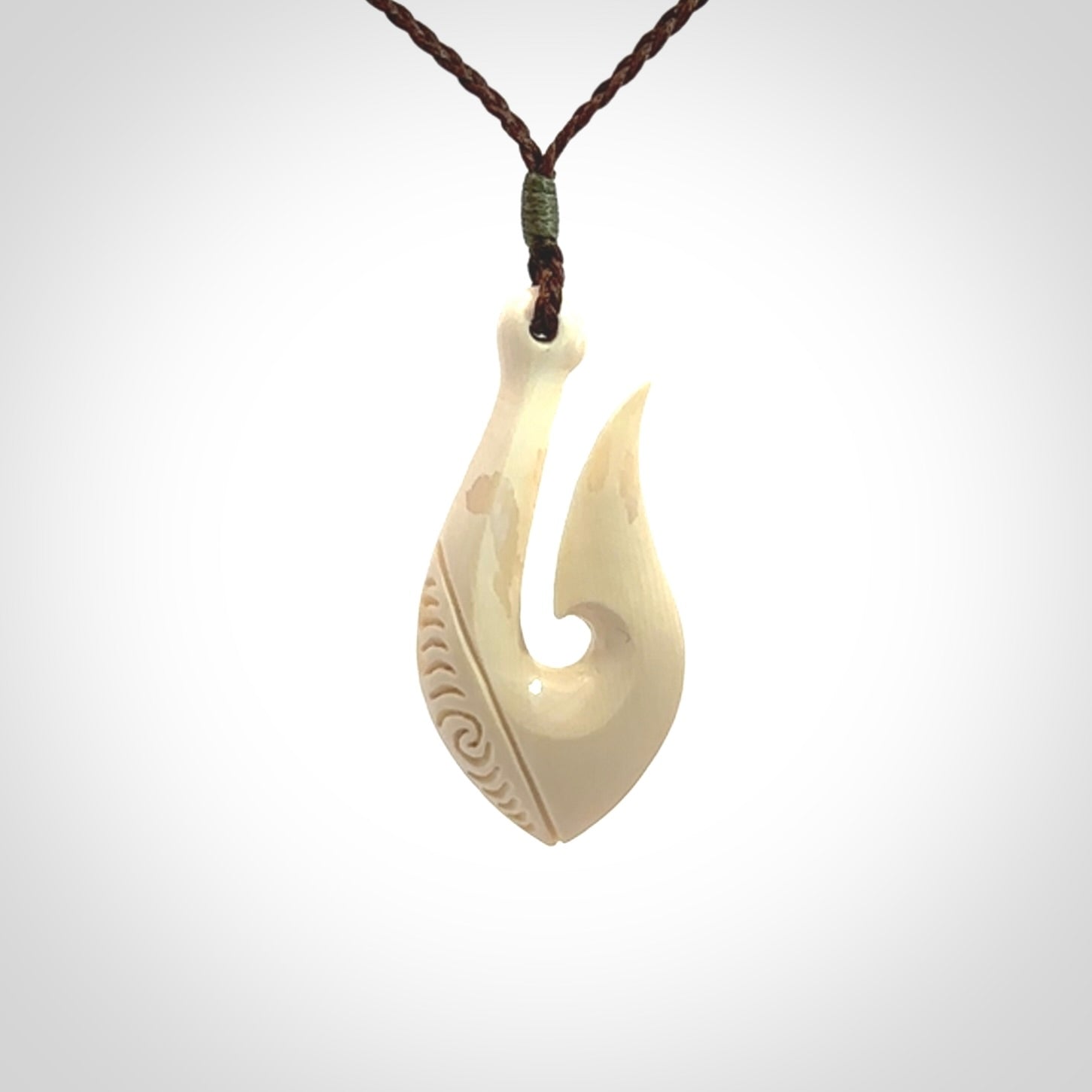 A fish hook necklace (hei-matau) hand-carved in a traditional style from Woolly Mammoth Tusk. Delivered on an adjustable cord in one of our kete pouches.