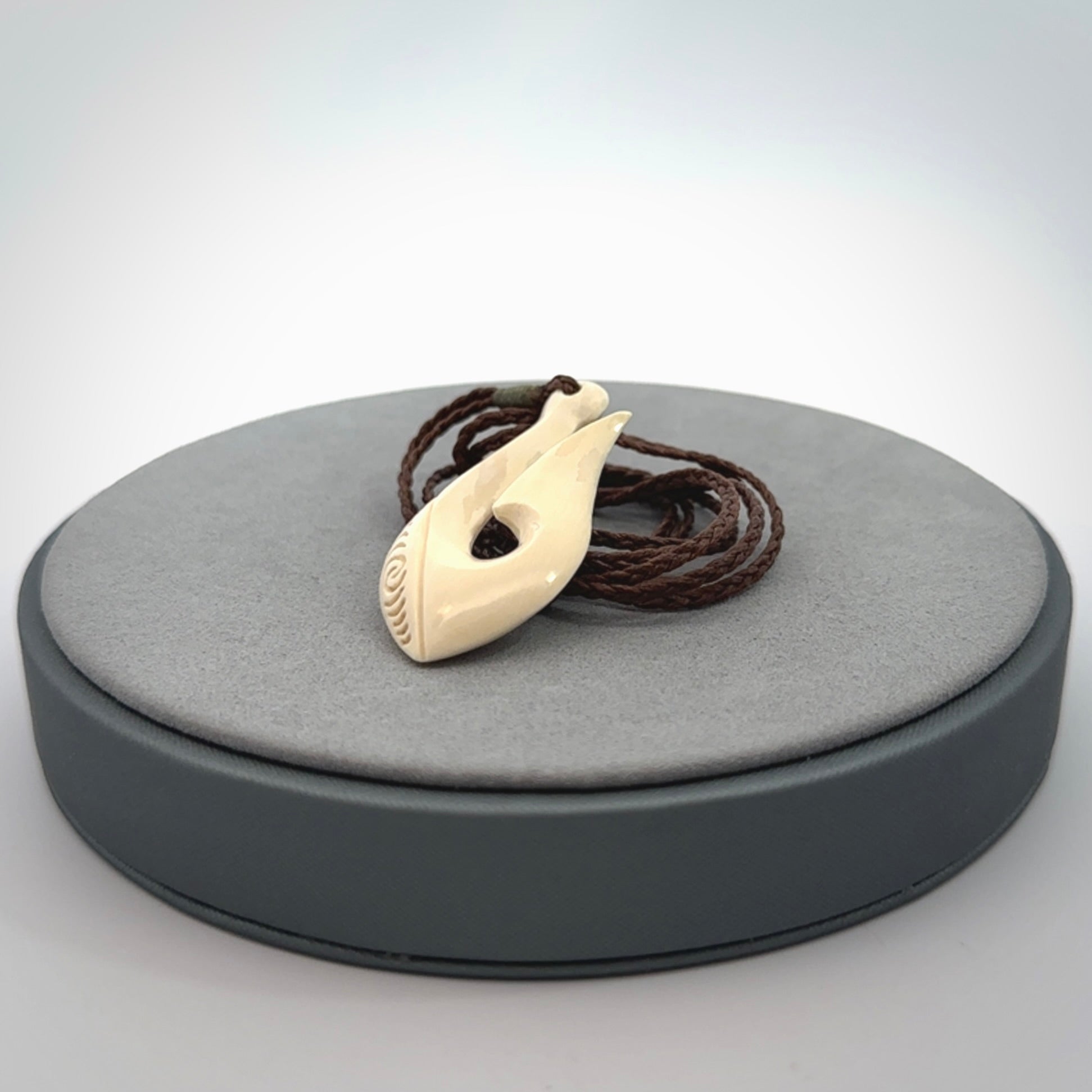 A fish hook necklace (hei-matau) hand-carved in a traditional style from Woolly Mammoth Tusk. Delivered on an adjustable cord in one of our kete pouches.