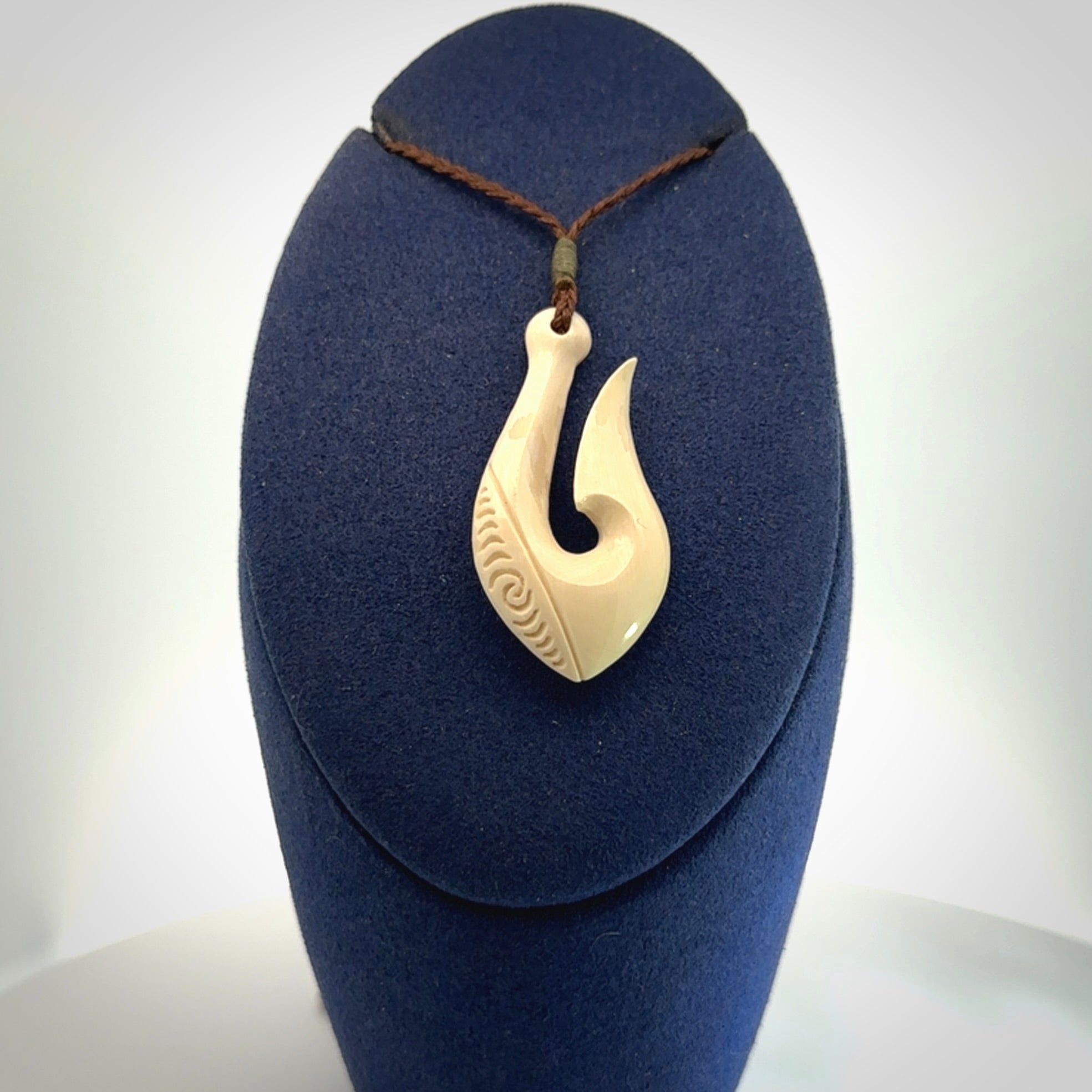 A fish hook necklace (hei-matau) hand-carved in a traditional style from Woolly Mammoth Tusk. Delivered on an adjustable cord in one of our kete pouches.