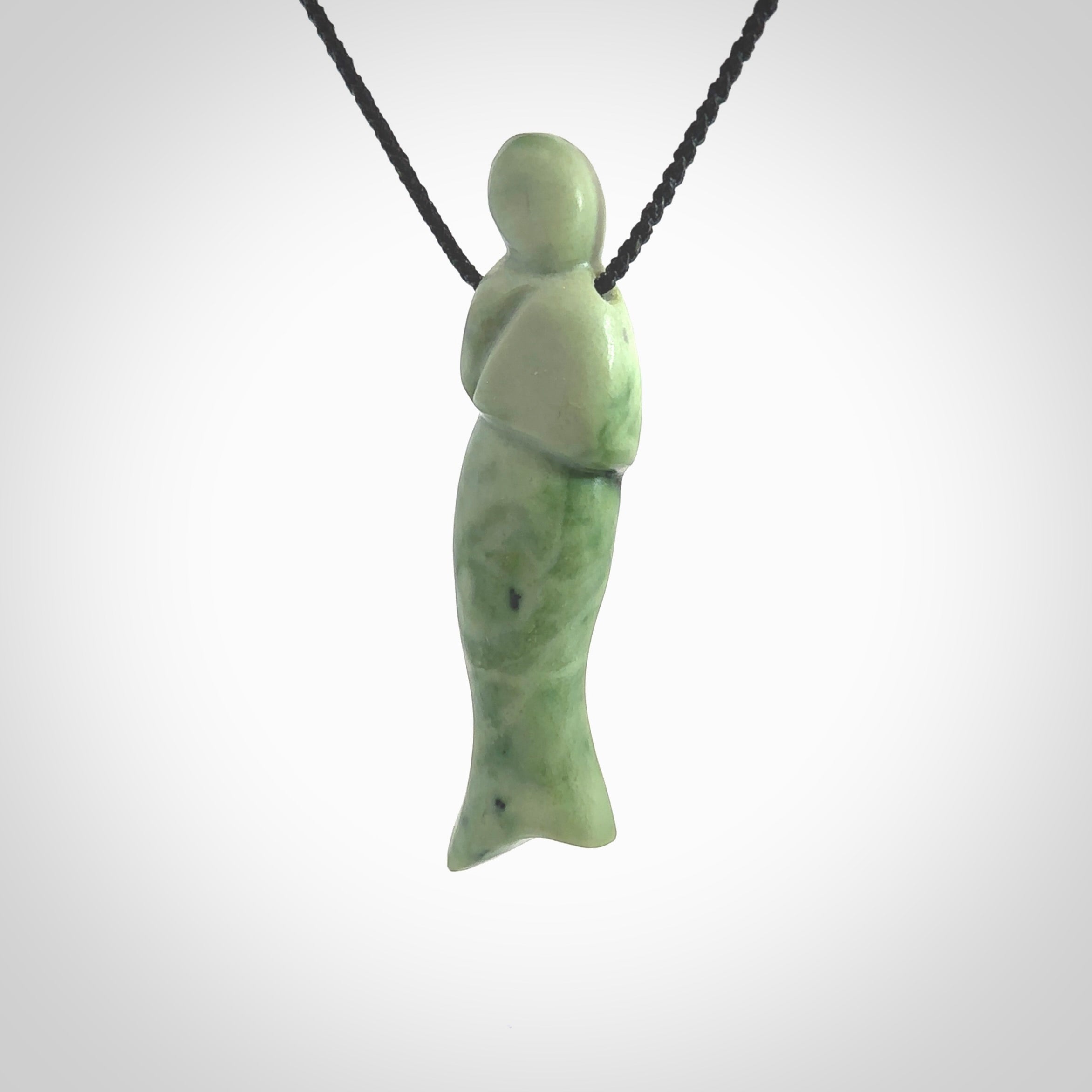 Hand carved New Zealand Jade woman drop pendant. Made by Ana Krakosky for NZ Pacific in New Zealand Pounamu, jade. A beautiful light green jade figure of a woman, drop necklace with black adjustable cord.