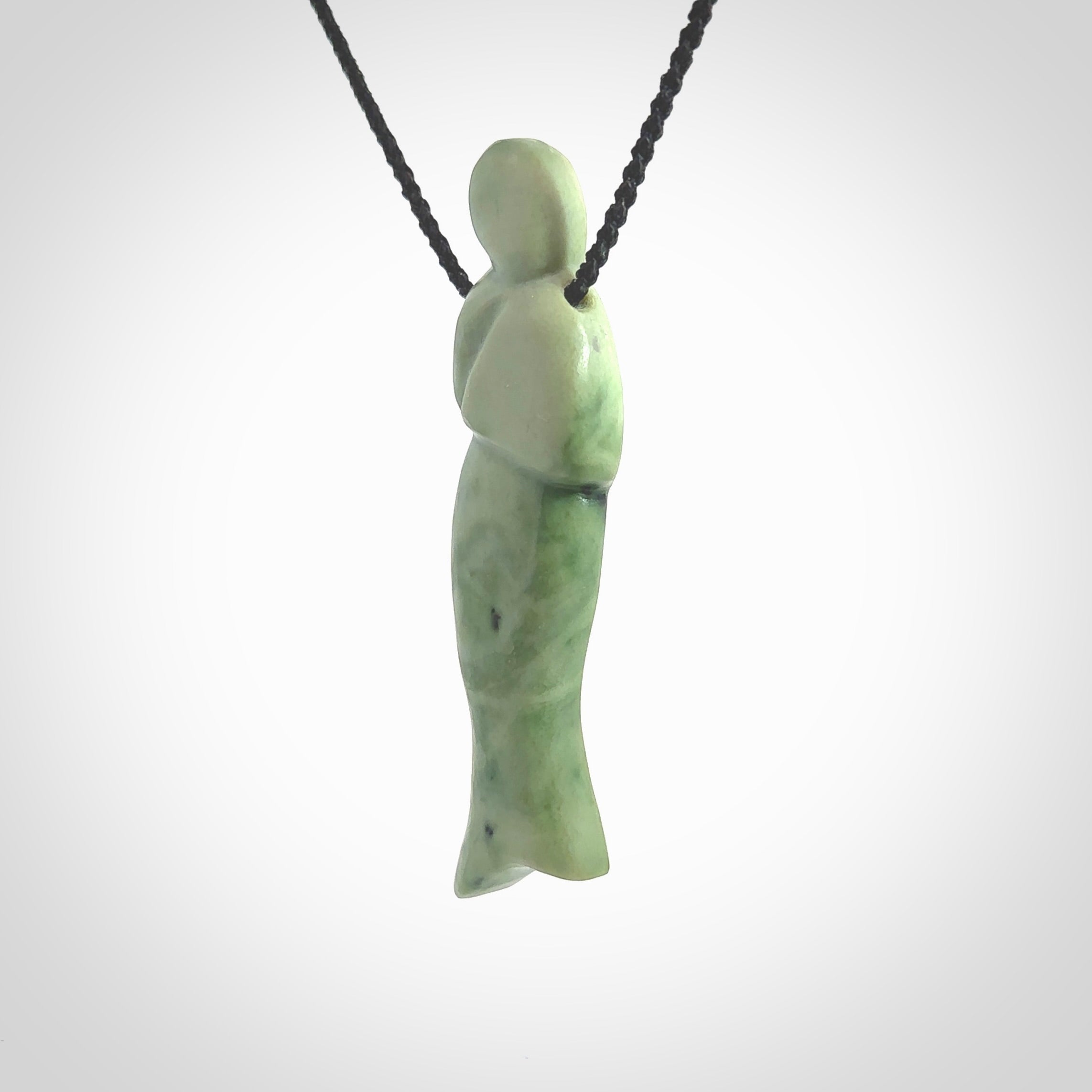 Hand carved New Zealand Jade woman drop pendant. Made by Ana Krakosky for NZ Pacific in New Zealand Pounamu, jade. A beautiful light green jade figure of a woman, drop necklace with black adjustable cord.
