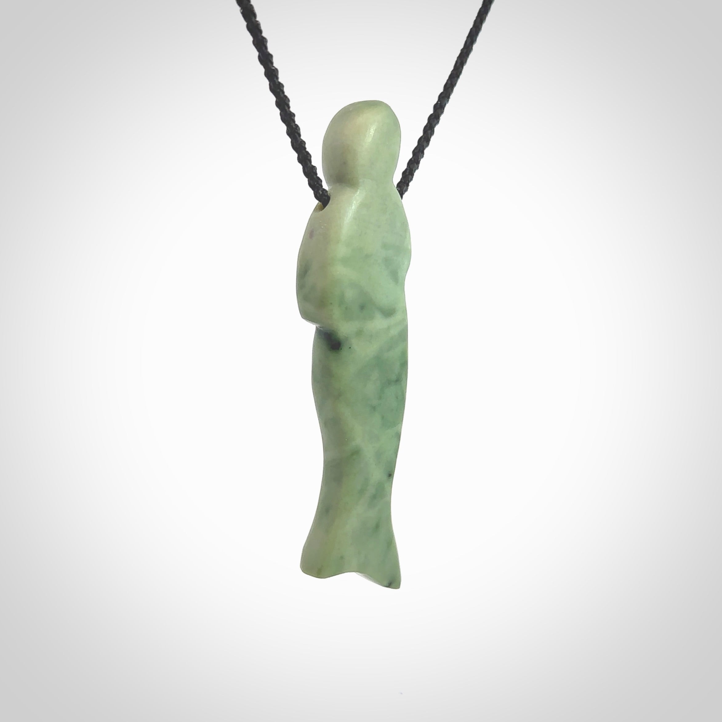 Hand carved New Zealand Jade woman drop pendant. Made by Ana Krakosky for NZ Pacific in New Zealand Pounamu, jade. A beautiful light green jade figure of a woman, drop necklace with black adjustable cord.