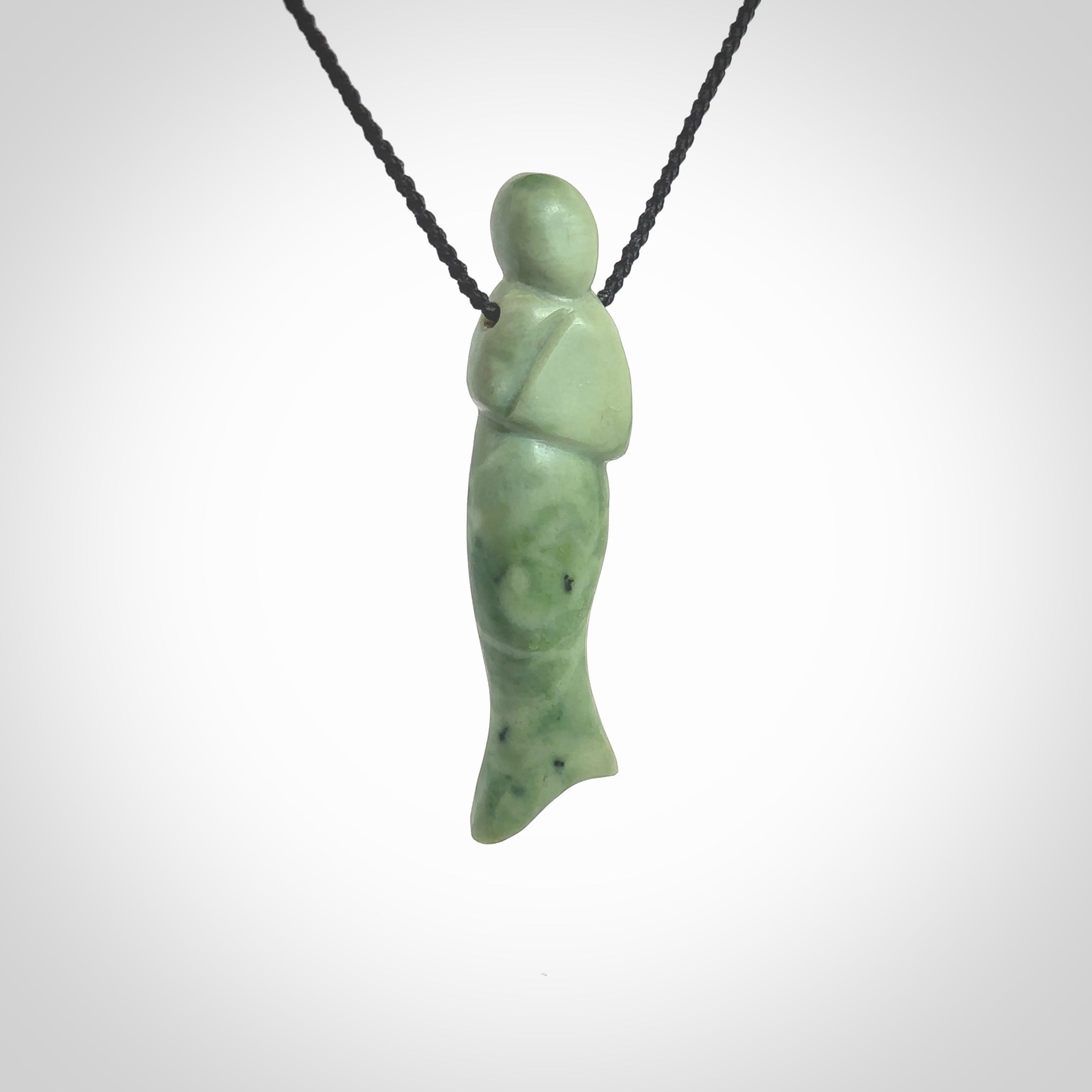 Hand carved New Zealand Jade woman drop pendant. Made by Ana Krakosky for NZ Pacific in New Zealand Pounamu, jade. A beautiful light green jade figure of a woman, drop necklace with black adjustable cord.