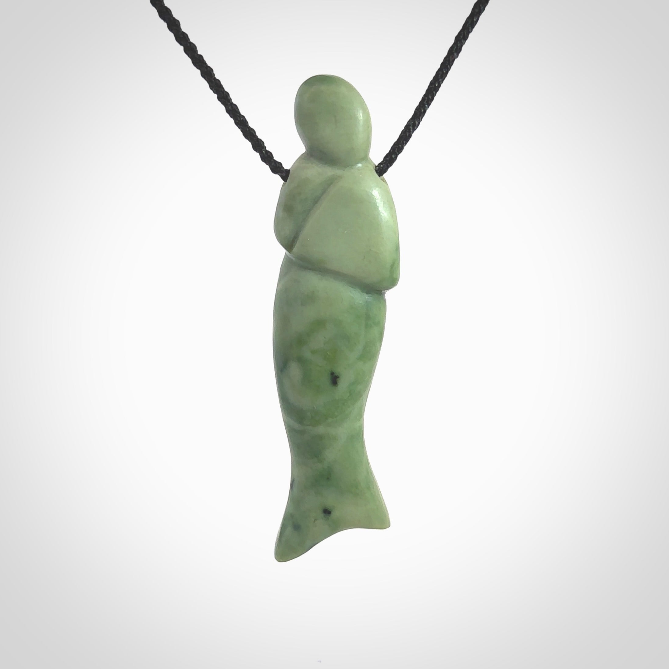 Hand carved New Zealand Jade woman drop pendant. Made by Ana Krakosky for NZ Pacific in New Zealand Pounamu, jade. A beautiful light green jade figure of a woman, drop necklace with black adjustable cord.