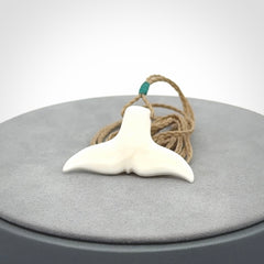This is a lovely little Dolphin tail pendant. We have hand carved this in a bright, white bone and we make the necklace from a hand-plaited waxed cord. These are original NZ Pacific pendants, handmade from natural materials.