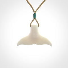 This is a lovely little Dolphin tail pendant. We have hand carved this in a bright, white bone and we make the necklace from a hand-plaited waxed cord. These are original NZ Pacific pendants, handmade from natural materials.