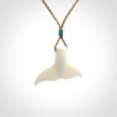 This is a lovely little Dolphin tail pendant. We have hand carved this in a bright, white bone and we make the necklace from a hand-plaited waxed cord. These are original NZ Pacific pendants, handmade from natural materials.