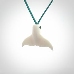 This is a lovely little Dolphin tail pendant. We have hand carved this in a bright, white bone and we make the necklace from a hand-plaited waxed cord. These are original NZ Pacific pendants, handmade from natural materials.