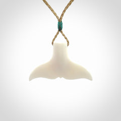 This is a lovely little Dolphin tail pendant. We have hand carved this in a bright, white bone and we make the necklace from a hand-plaited waxed cord. These are original NZ Pacific pendants, handmade from natural materials.