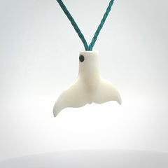 This is a lovely little Dolphin tail pendant. We have hand carved this in a bright, white bone and we make the necklace from a hand-plaited waxed cord. These are original NZ Pacific pendants, handmade from natural materials.