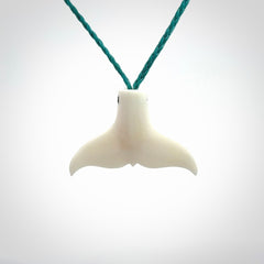 This is a lovely little Dolphin tail pendant. We have hand carved this in a bright, white bone and we make the necklace from a hand-plaited waxed cord. These are original NZ Pacific pendants, handmade from natural materials.