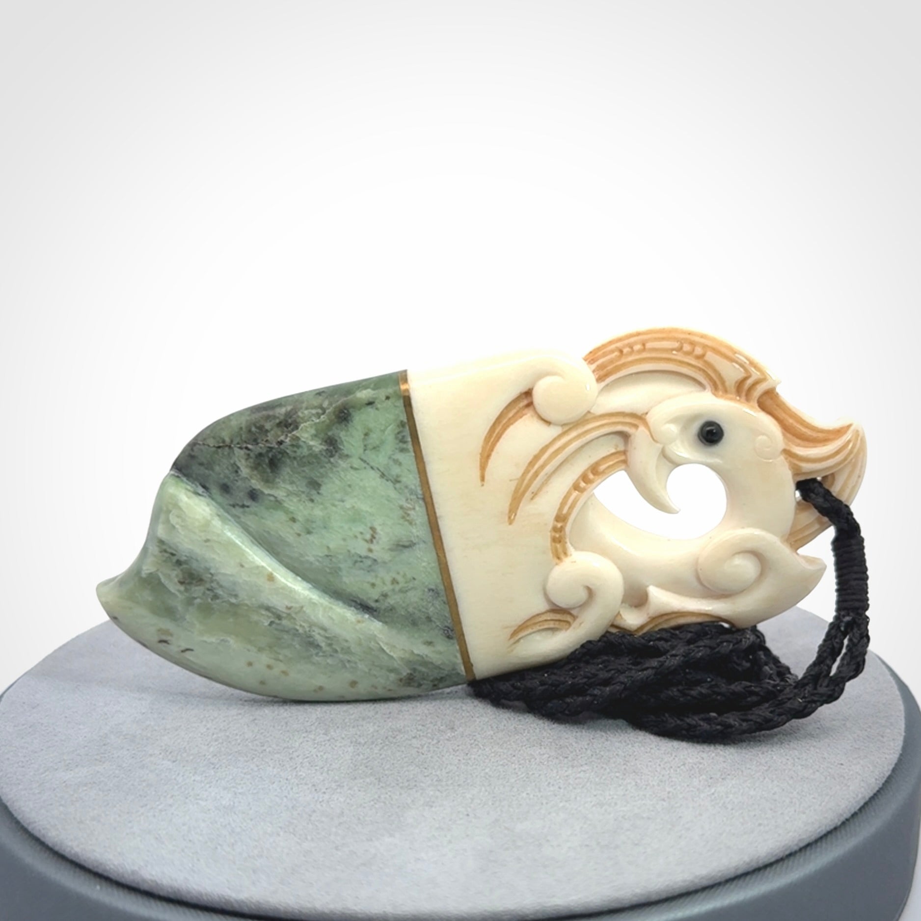 This is a large carved Kea pendant. It is made from three materials - New Zealand Jade, Bone, Brass.