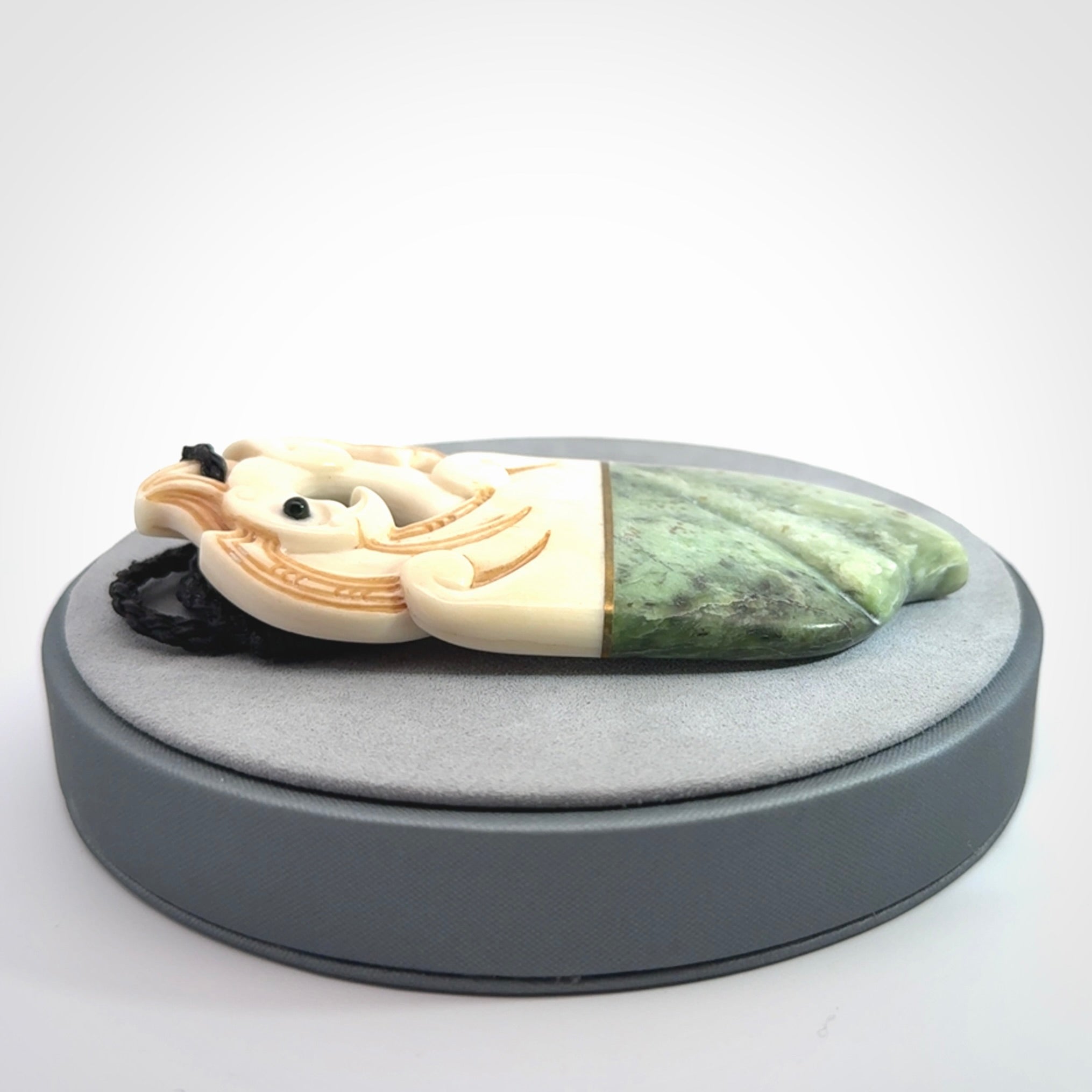 This is a large carved Kea pendant. It is made from three materials - New Zealand Jade, Bone, Brass.