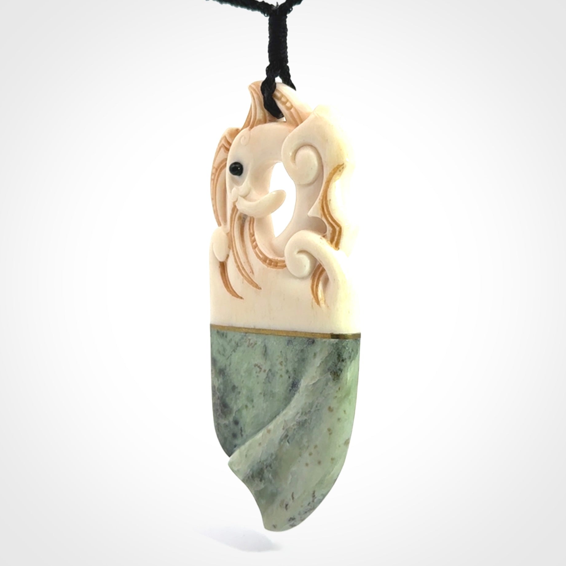 This is a large carved Kea pendant. It is made from three materials - New Zealand Jade, Bone, Brass.