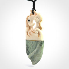 This is a large carved Kea pendant. It is made from three materials - New Zealand Jade, Bone, Brass.