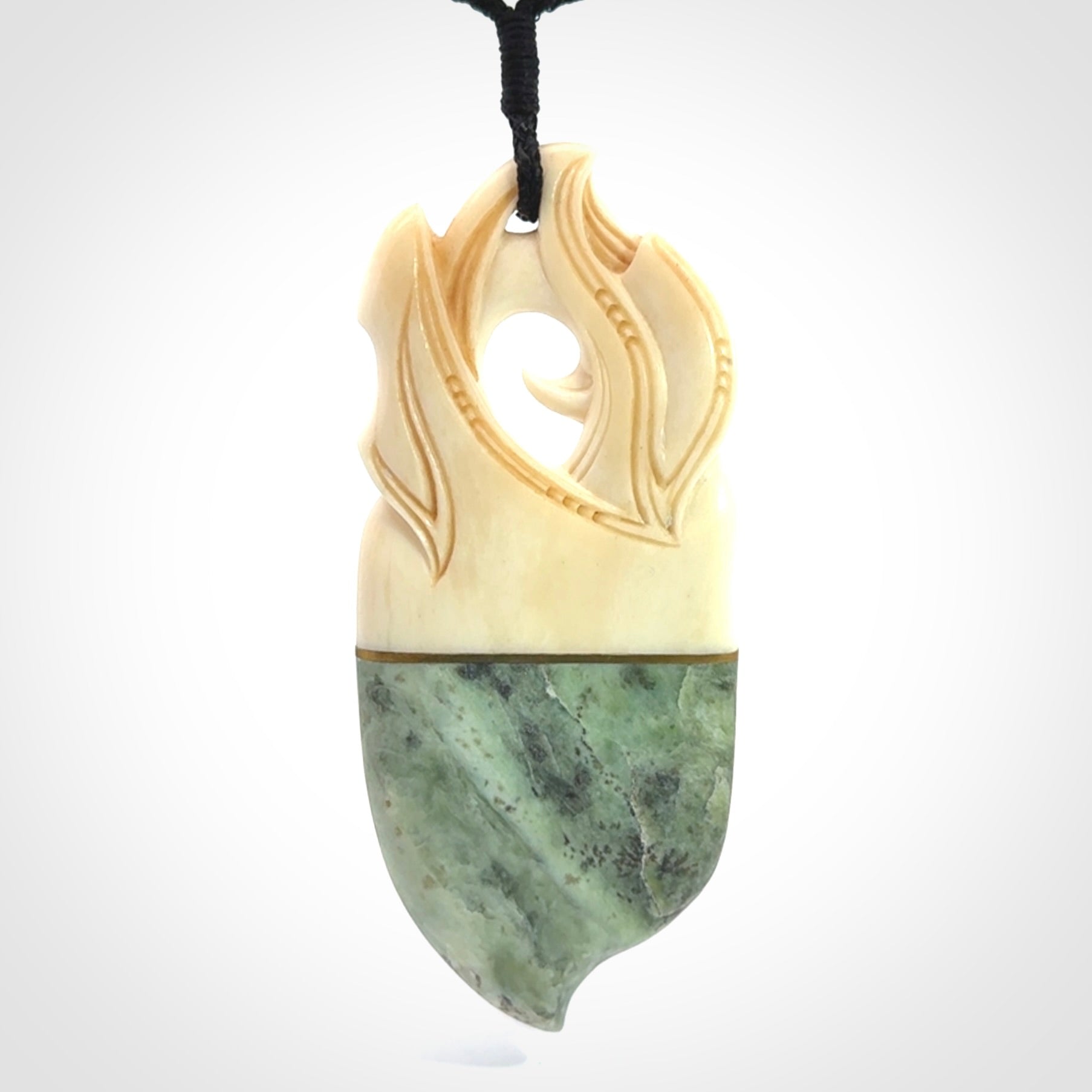 This is a large carved Kea pendant. It is made from three materials - New Zealand Jade, Bone, Brass.