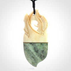 This is a large carved Kea pendant. It is made from three materials - New Zealand Jade, Bone, Brass.