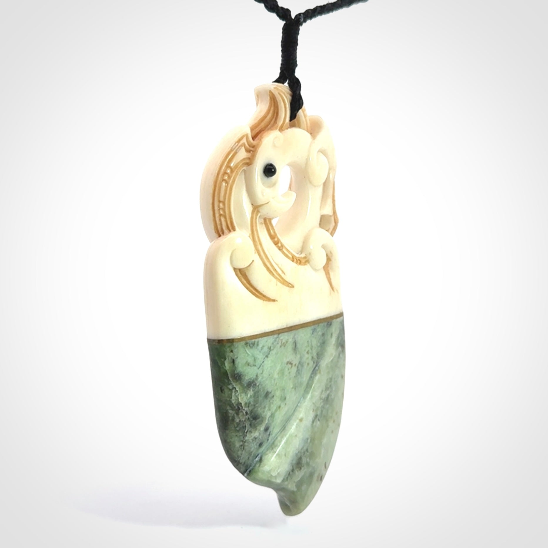 This is a large carved Kea pendant. It is made from three materials - New Zealand Jade, Bone, Brass.