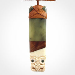 This is a large carved Koruru pendant. It is made from New Zealand Jade, Bone, Kauri wood and Brass. The face of the Koruru is carved with a traditional design in the front. It has a protruding tongue which is also carved and the back face has traditional carved designs. This is a large and very traditional pendant that is a collectors piece.
