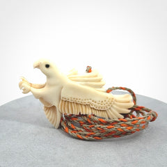 This picture shows a carved kea pendant in bone. It is provided with a hand-plaited orange and olive cord that is length adjustable. Shipping is included and we ship worldwide.