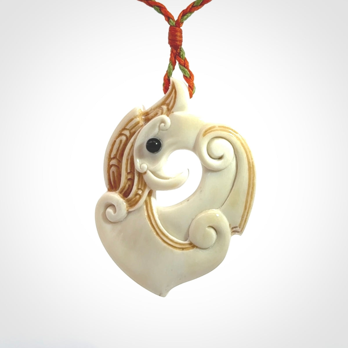 This picture shows a carved kea pendant in bone. It is provided with a hand-plaited orange and green cord that is length adjustable. Shipping is included and we ship worldwide.