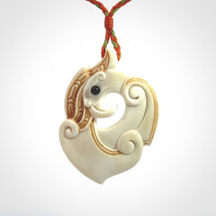 This picture shows a carved kea pendant in bone. It is provided with a hand-plaited orange and green cord that is length adjustable. Shipping is included and we ship worldwide.