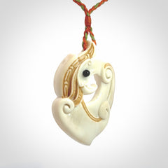 This picture shows a carved kea pendant in bone. It is provided with a hand-plaited orange and green cord that is length adjustable. Shipping is included and we ship worldwide.