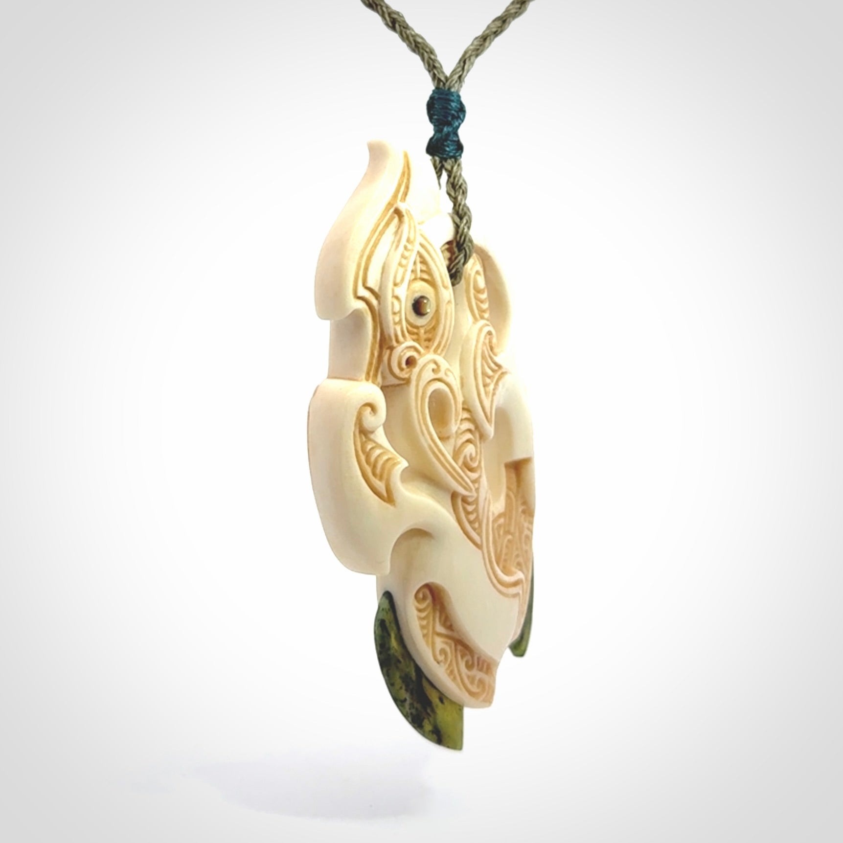 This picture shows a carved manaia in bone with Jade and Paua shell. It is provided with a hand-plaited fern green cord that is length adjustable. Free shipping worldwide.