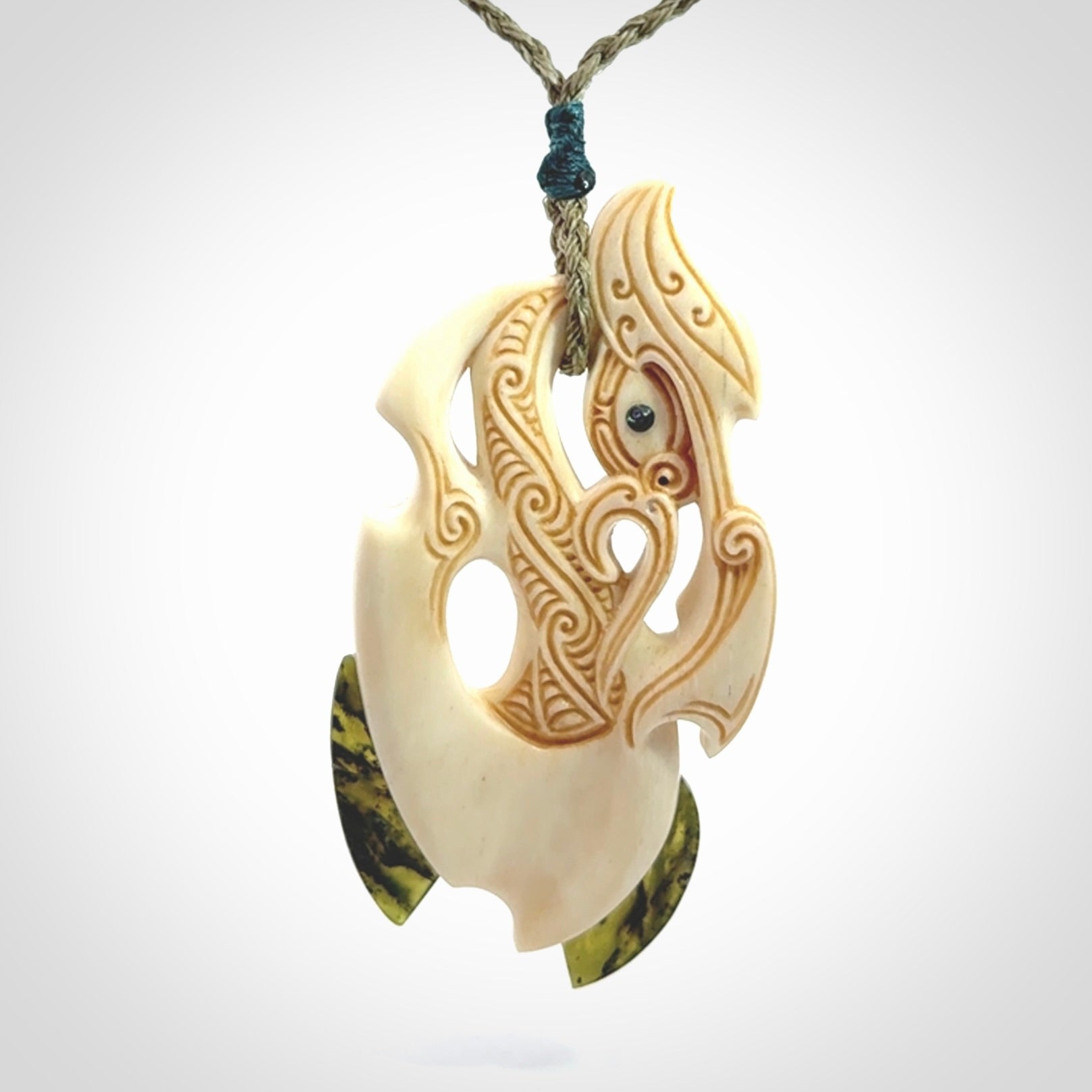 This picture shows a carved manaia in bone with Jade and Paua shell. It is provided with a hand-plaited fern green cord that is length adjustable. Free shipping worldwide.
