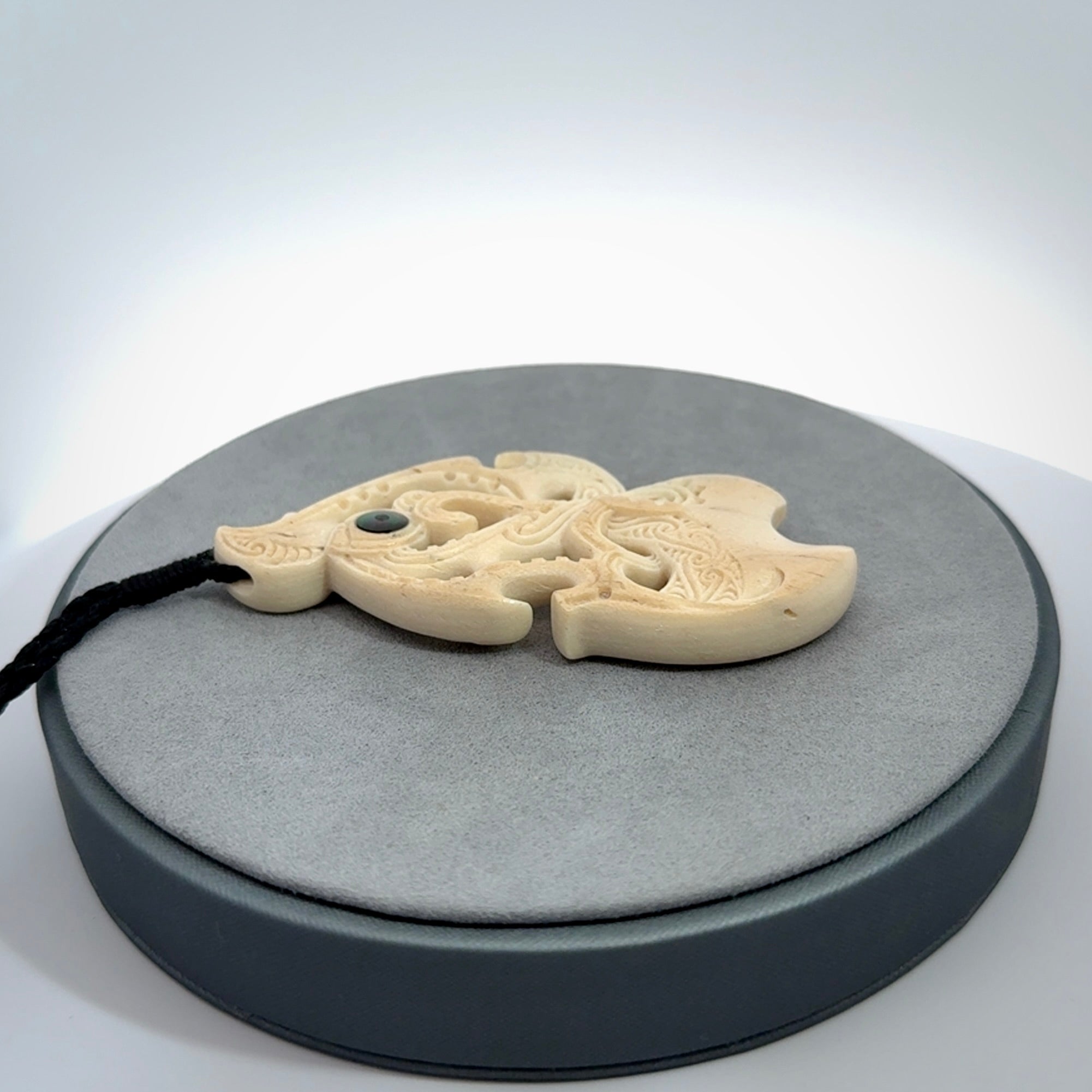 This is a wonderful, finely carved Manaia pendant. It is hand carved by Andrew Doughty and we will ship it to you free anywhere in the world. Hand made from whale bone and delivered to you with an adjustable black cord. Packaged in a woven kete pouch.