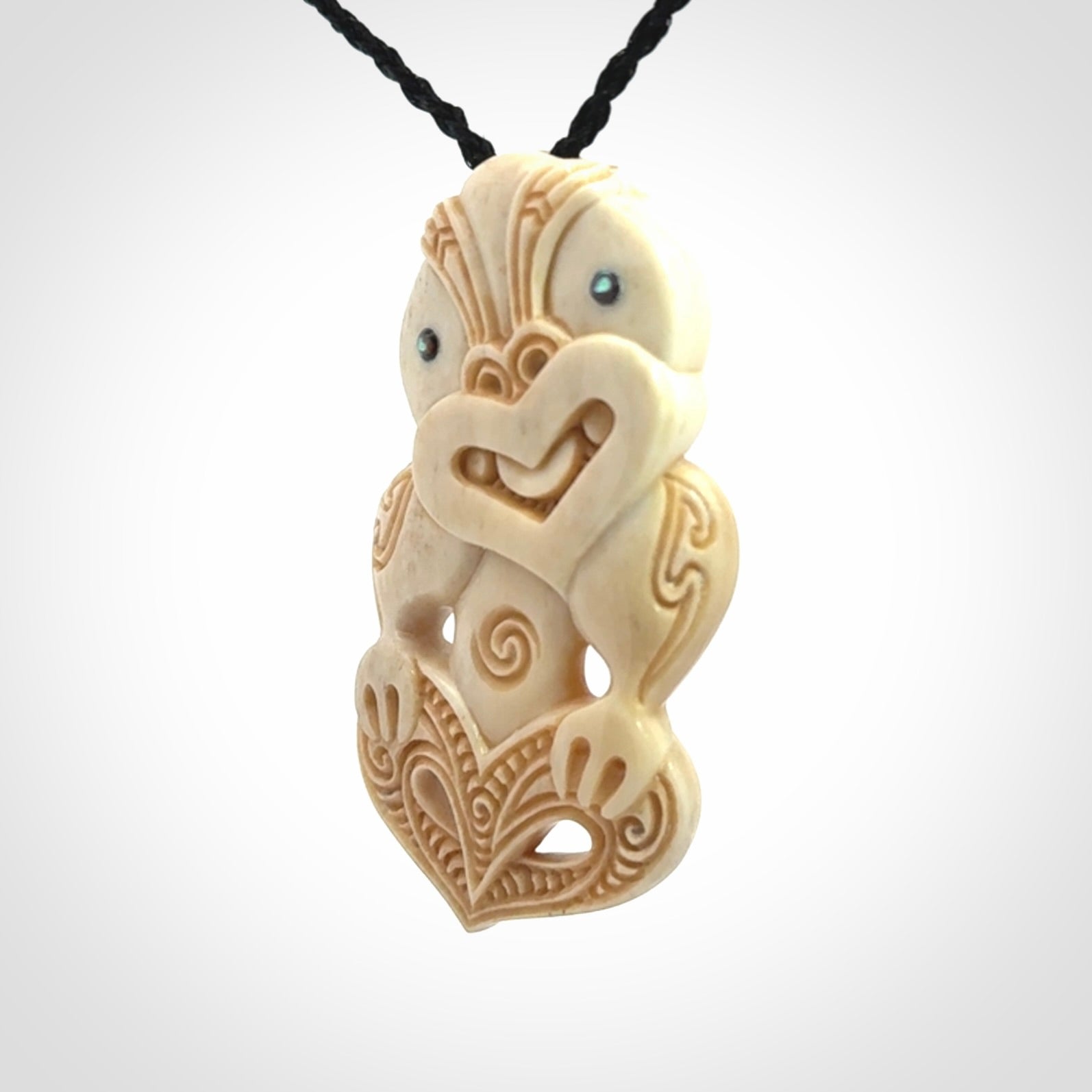 This picture shows a carved Tiki pendant in bone. It is provided with a hand-plaited black cord that is length adjustable.