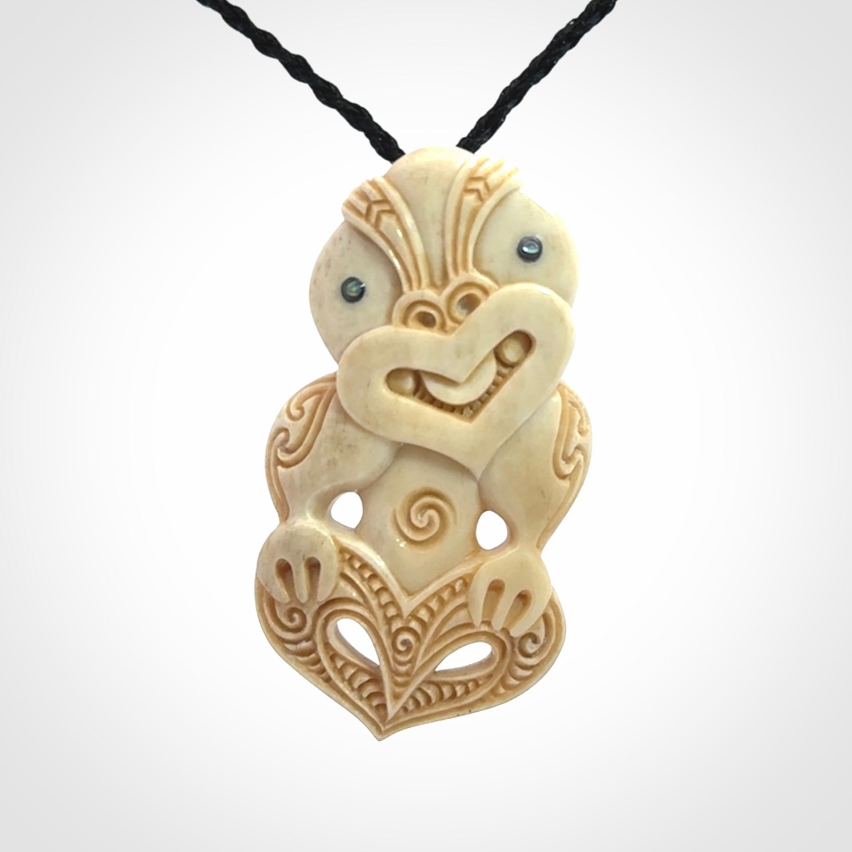 This picture shows a carved Tiki pendant in bone. It is provided with a hand-plaited black cord that is length adjustable.