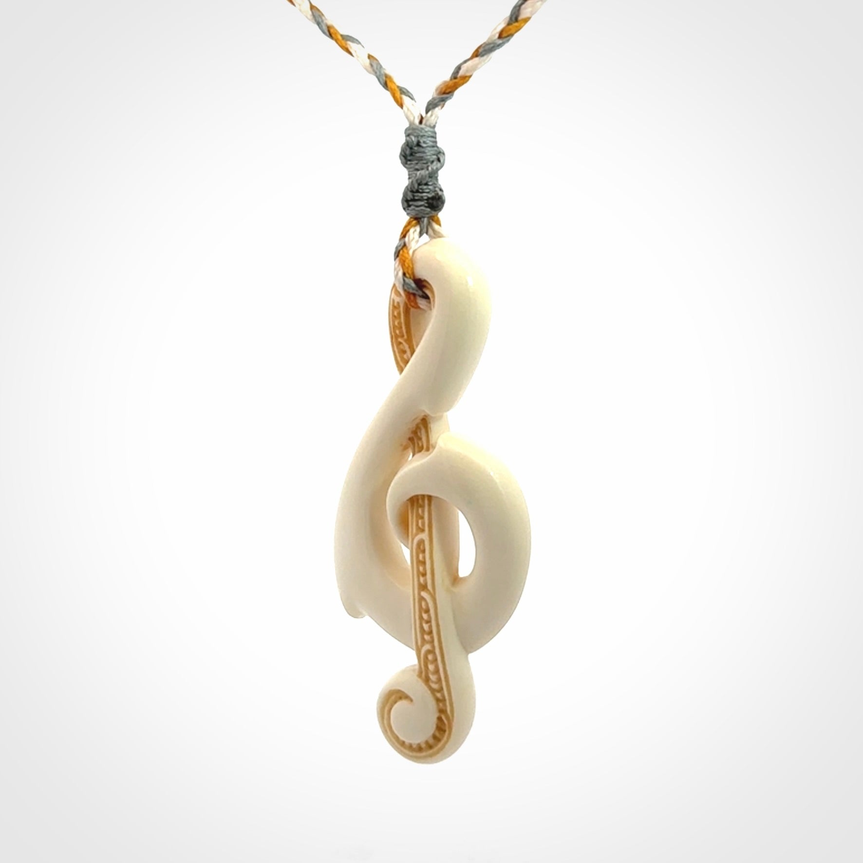 A Beautifully Carved Treble Clef Pendant in Bone