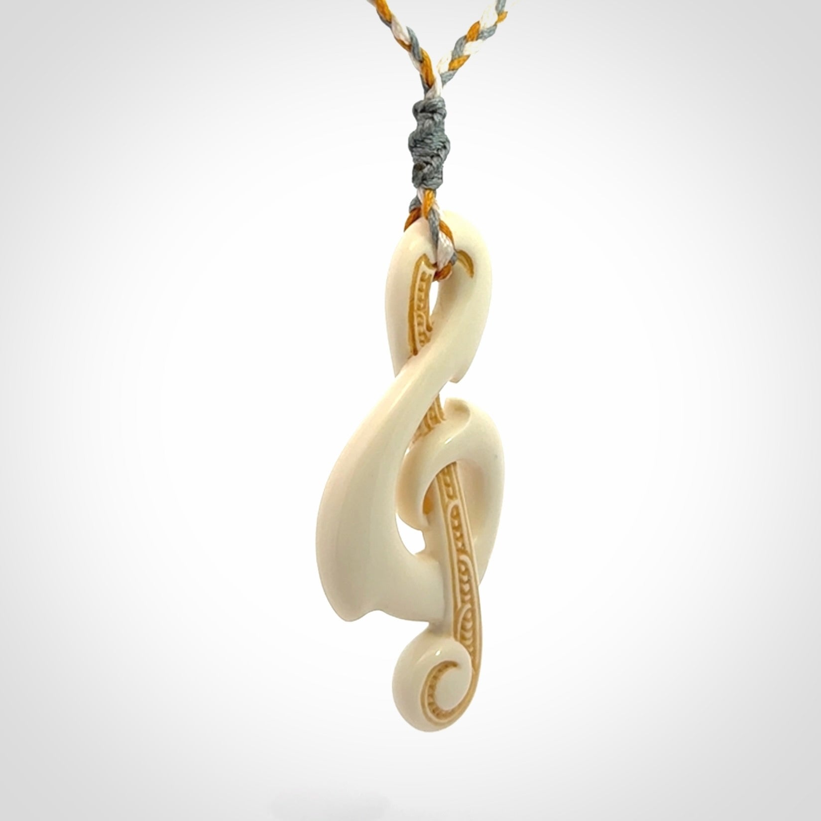 A Beautifully Carved Treble Clef Pendant in Bone