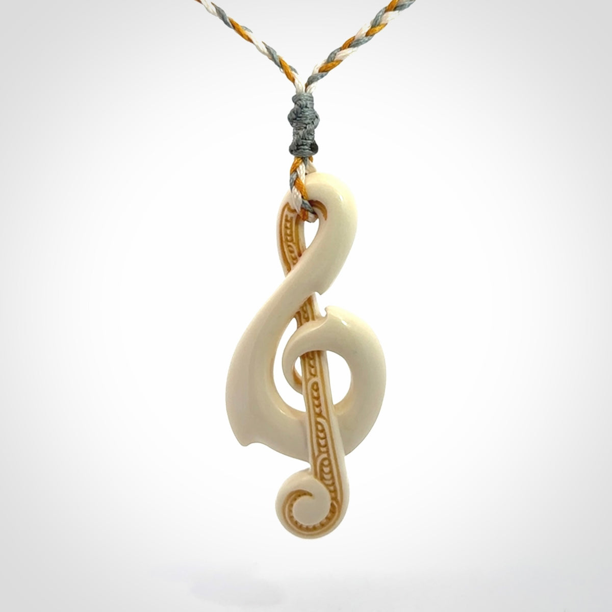 A Beautifully Carved Treble Clef Pendant in Bone