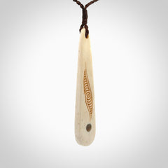 This is a wonderful, finely carved bone drop pendant with paua shell inlay.