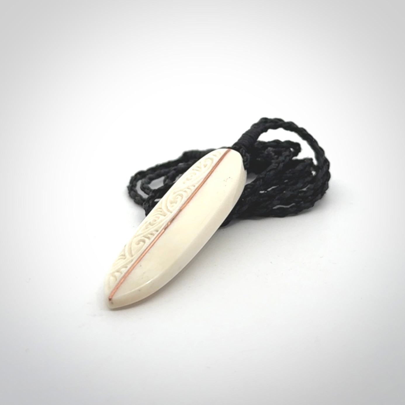 This is a wonderful, finely carved drop pendant. Hand made from bone with copper inlay and delivered to you with an adjustable black cord.