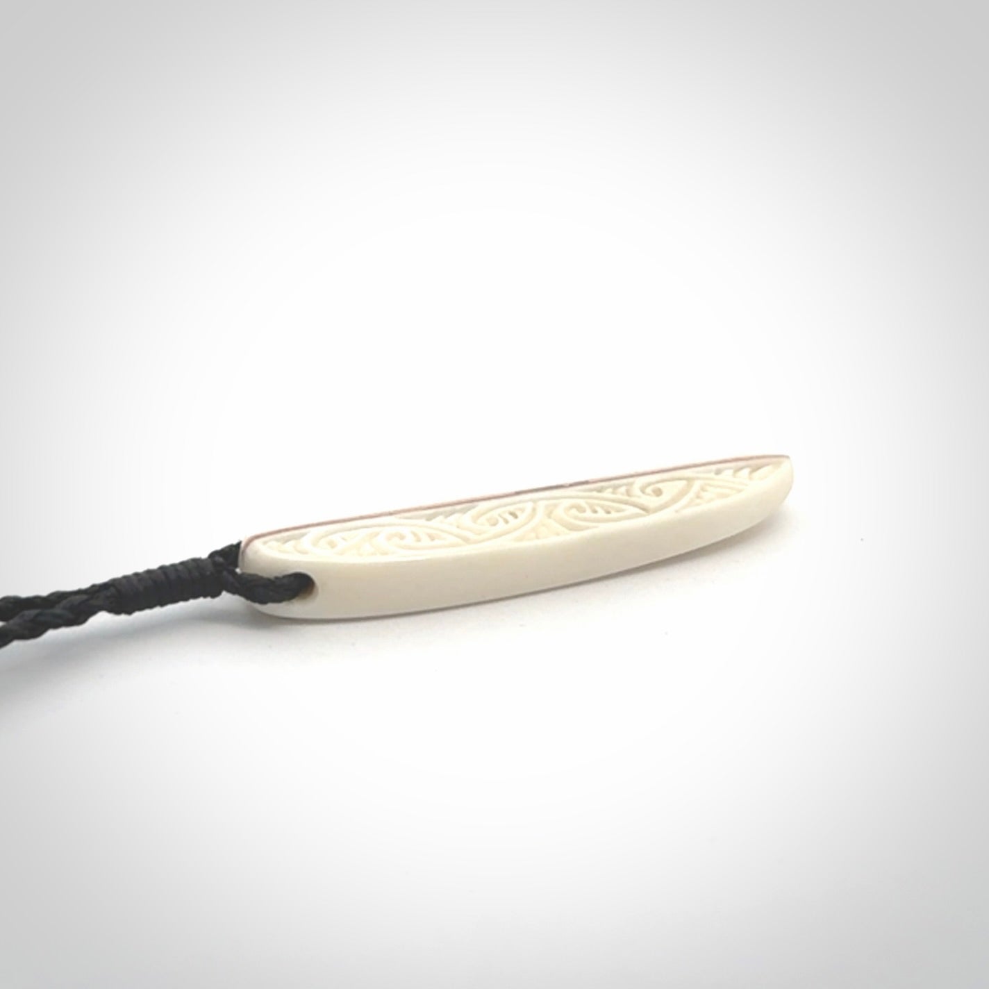 This is a wonderful, finely carved drop pendant. Hand made from bone with copper inlay and delivered to you with an adjustable black cord.