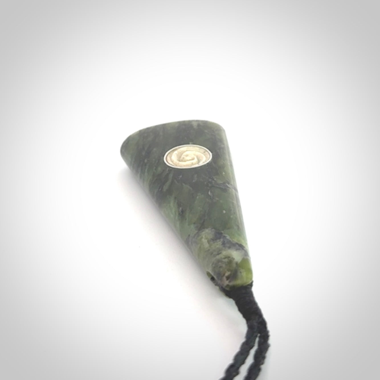 This is a wonderful New Zealand Jade drop pendant with whale bone koru and brass inlay.