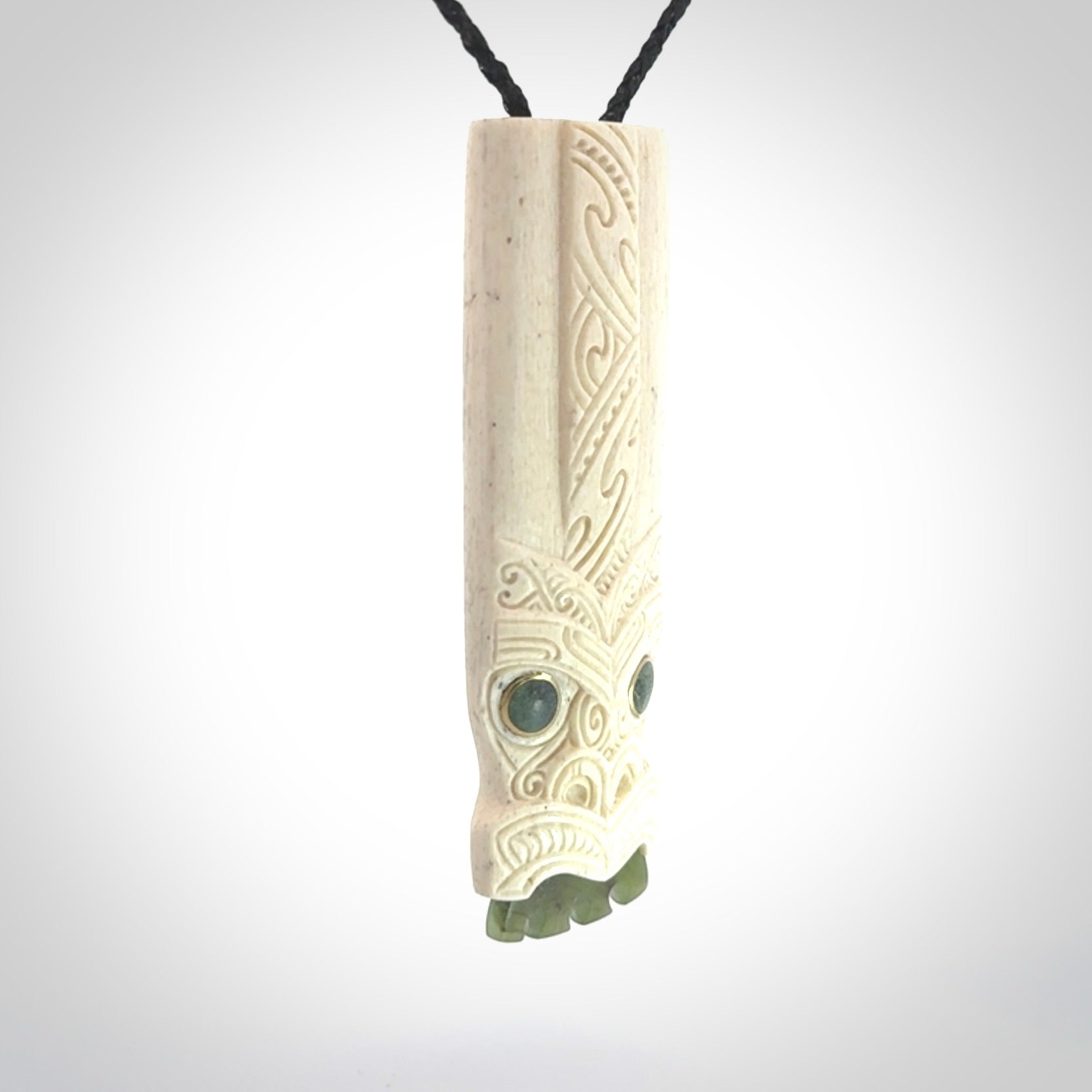 This is a wonderful, finely carved Koruru pendant. It is hand carved by Andrew Doughty and we will ship it to you free anywhere in the world. Hand made from whale bone with Jade, Aotea Stone inlay. Delivered to you with an adjustable black cord.