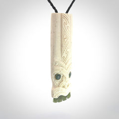 This is a wonderful, finely carved Koruru pendant. It is hand carved by Andrew Doughty and we will ship it to you free anywhere in the world. Hand made from whale bone with Jade, Aotea Stone inlay. Delivered to you with an adjustable black cord.