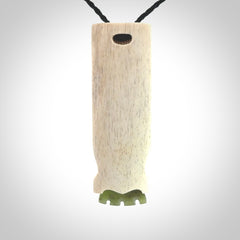 This is a wonderful, finely carved Koruru pendant. It is hand carved by Andrew Doughty and we will ship it to you free anywhere in the world. Hand made from whale bone with Jade, Aotea Stone inlay. Delivered to you with an adjustable black cord.