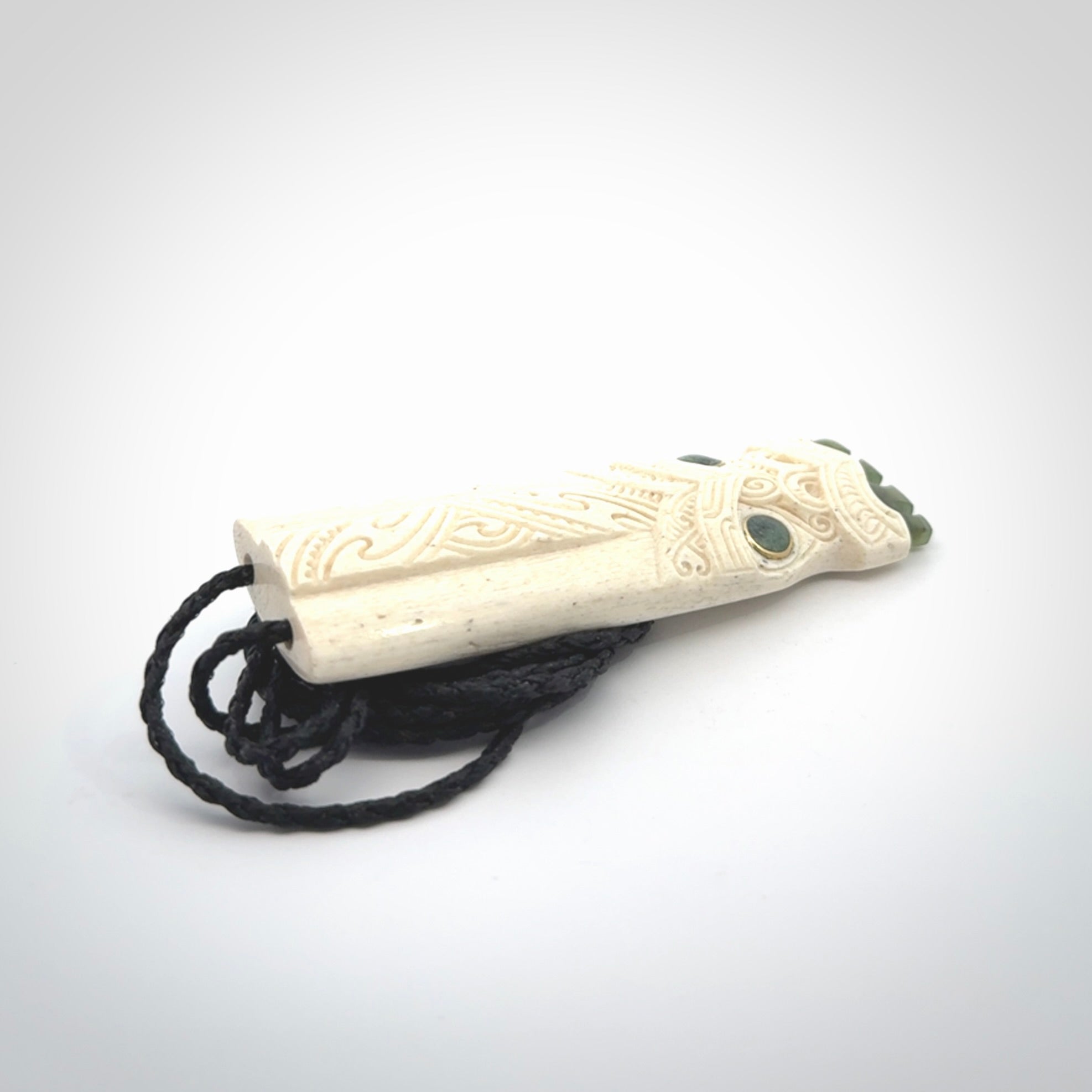 This is a wonderful, finely carved Koruru pendant. It is hand carved by Andrew Doughty and we will ship it to you free anywhere in the world. Hand made from whale bone with Jade, Aotea Stone inlay. Delivered to you with an adjustable black cord.