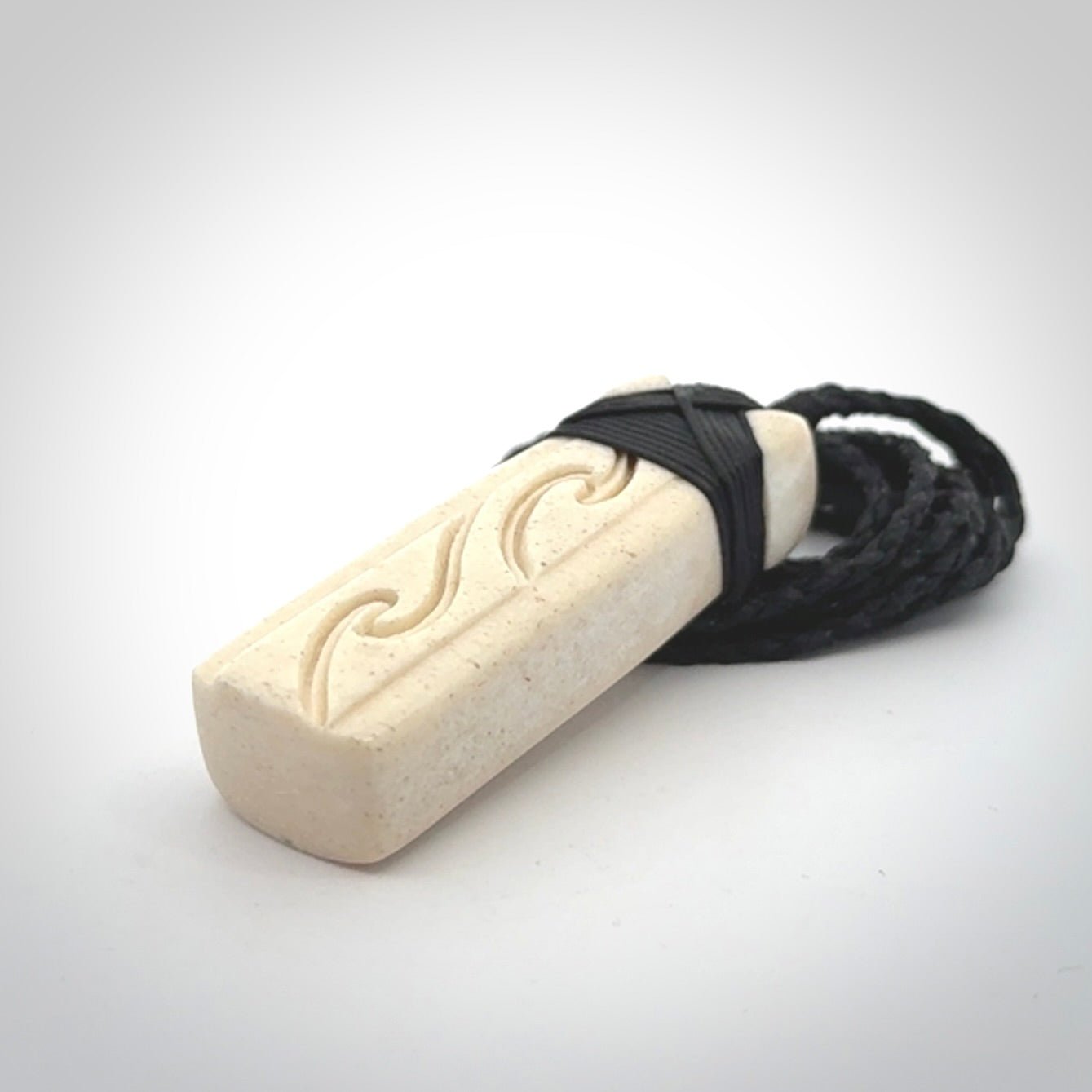 This is a wonderful, finely carved Toki pendant. It is hand carved by Andrew Doughty and we will ship it to you free anywhere in the world. Hand made from whale bone. Delivered to you with an adjustable black cord.